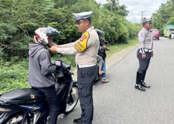 Kanit Turjawali, Bripka Mathius Pither Tato, memberikan edukasi kepada pengendara sepeda motor terkait dengan pelaksanaan operasi serta aturan lalu lintas. (F. Zulkifli/ Gorontalo Post)