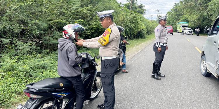 Kanit Turjawali, Bripka Mathius Pither Tato, memberikan edukasi kepada pengendara sepeda motor terkait dengan pelaksanaan operasi serta aturan lalu lintas. (F. Zulkifli/ Gorontalo Post)