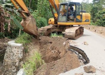 Alat berat excavator bantuan PT Pabrik Gula Gorontalo yang dipinjamkan untuk memperbaiki jalan sekaligus plat duiker putus di Jalan Mulyonegoro Desa Karyamukti Kecamatan Pulubala Kabupaten Gorontalo beberapa Waktu lalu. (Foto: Istimewa).