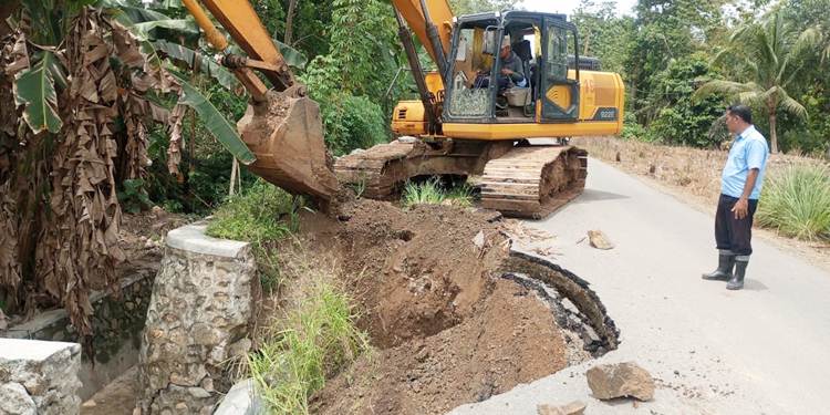 Alat berat excavator bantuan PT Pabrik Gula Gorontalo yang dipinjamkan untuk memperbaiki jalan sekaligus plat duiker putus di Jalan Mulyonegoro Desa Karyamukti Kecamatan Pulubala Kabupaten Gorontalo beberapa Waktu lalu. (Foto: Istimewa).
