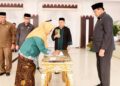 Seorang Pejabat Fungsional Ahli Madya menandatangani berita acara pada pelantikan di aula rumah jabatan Gubernur Gorontalo, Selasa (23/12/2025). (Foto : Haris/diskominfotik)