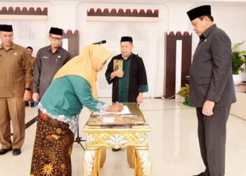 Seorang Pejabat Fungsional Ahli Madya menandatangani berita acara pada pelantikan di aula rumah jabatan Gubernur Gorontalo, Selasa (23/12/2025). (Foto : Haris/diskominfotik)