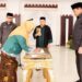 Seorang Pejabat Fungsional Ahli Madya menandatangani berita acara pada pelantikan di aula rumah jabatan Gubernur Gorontalo, Selasa (23/12/2025). (Foto : Haris/diskominfotik)