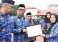 Wagub Idah Syahidah Rusli Habibie menyerahkan penghargaan The Best ASN of The Month pada apel akbar HUT ke-54 Korpri dan HUT ke-25 Provinsi Gorontalo di halaman Museum Purbakala, Senin (1/12). (Foto : Haris/diskominfotik)