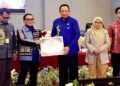 Gubernur Gorontalo Gusnar Ismail menyerahkan piagam penghargaan kepada Kepala Perwakilan BI Gorontalo Bambang Setya Permana, atas dedikasinya dalam mengendalikan inflasi pada HLM TPID yang berlangsung di Hulonthalo Ballroom, Kota Gorontalo, Kamis (4/12). (Foto : Haris/diskominfotik)