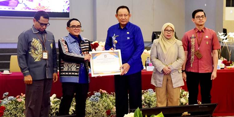 Gubernur Gorontalo Gusnar Ismail menyerahkan piagam penghargaan kepada Kepala Perwakilan BI Gorontalo Bambang Setya Permana, atas dedikasinya dalam mengendalikan inflasi pada HLM TPID yang berlangsung di Hulonthalo Ballroom, Kota Gorontalo, Kamis (4/12). (Foto : Haris/diskominfotik)