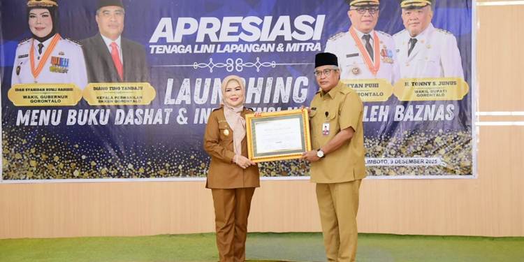 Kepala BKKBN Provinsi Gorontalo Diano Tino Tandaju saat menyerahkan penghargaan dari BKKBN RI kepada Wakil Gubernur Gorontalo Idah Syahidah Rusli Habibie Bunda Akselerasi Penurunan Stunting di Provinsi Gorontalo. (Foto – Nova/Diskominfotik).