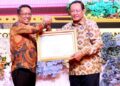 Gubernur Gorontalo Gusnar Ismail (kanan), menerima penghargaan dari Menteri Hukum atas pencapaian 100 persen Posbakum di Gedung Azalea, Kota Gorontalo, Jumat (28/11/2025). (Foto : Mila/diskominfotik)