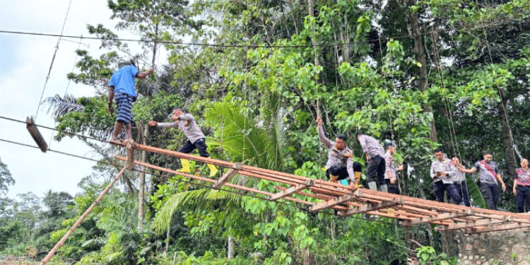Personel Brimob Polda Gorontalo dibantu oleh masyarakat sekitar, melakukan perbaikan jembatan yang putus di Dusun Mohulo, Desa Molalahu, Kecamatan Pulubala, Kabupaten Gorontalo.