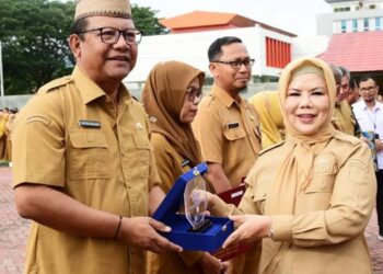 Wakil Gubernur Gorontalo Idah Syahidah Rusli Habibie saat menyerahkan piagam penghargaan kepada Sekretaris Daerah Sofian Ibrahim untuk hasil evaluasi implementasi SAKIB kepada Sekretariat Daerah di Apel Perdana 2026, Senin, (5/1/2026). (Foto: Nova- Diskominfotik).