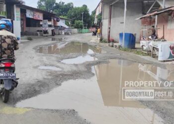Kondisi jalan yang merupakan akses Utama di Kawasan pasar Talaga Desa Hulawa Kabupaten Gorontalo banyak kubangan besar yang mengganggu pengunjung pasar. (Foto: Roy/Gorontalo Post)