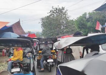 Sejumlah Pengemudi bentor dengan santainnya memarkir bentor mereka di tengah badan jalan bahkan mengabaikan larangan petugas Dishub Kota Goronalo yang dikerahkan untuk mengurai kemacetan parah di lokasi pasar terminal 42 Kota Gorontalo. (Foto: Roy/Gorontalo Post)