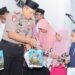 Kapolres Pohuwato, AKBP H. Busroni,S.I.K.,M.H. didampingi Ketua Bhayangkari Cabang Pohuwato, menyerahkan santunan kepada anak yatim.