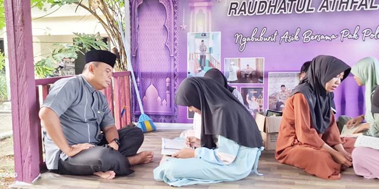 Kapolres Pohuwato, AKBP H. Busroni,S.I.K.,M.H. saat mengajar menulis dan membaca Al-Qur’an kepada anak-anak yang ada di Kecamatan Dengilo.