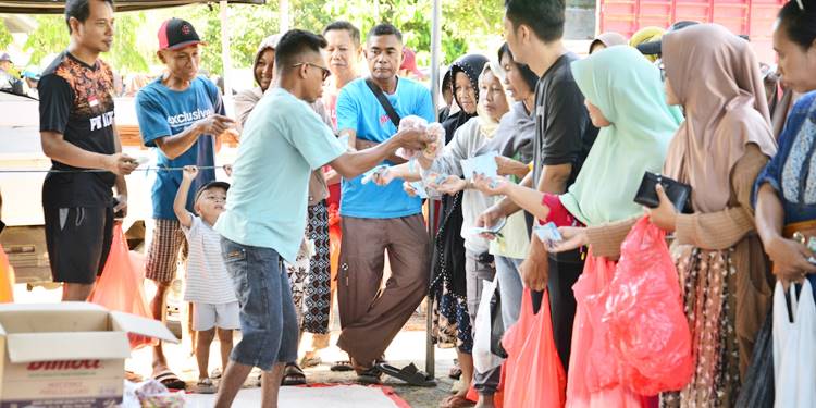 ANTUSIAS: Seorang petugas melayani warga yang datang antusias berbelanja di pasar murah yang diselenggarakan di Desa Yosonegoro, Kabupaten Goronalo, Kamis (26/3). (foto: dok-diskominfotikprov)