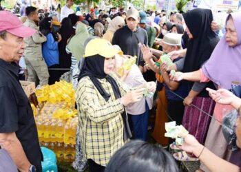 PAKAI KUPON: Wakil Gubernur Idah Syahidah RH turut melayani warga yang berbelanja di pasar murah yang digelar Pemprov Gorontalo di halaman Masjid Agung Tilamuta, Sabtu (7/3). (foto: dok-pemprov)