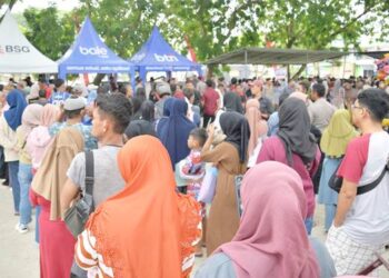 Warga mengantri untuk penukaran kupon belanja di pasar murah bersubsidi yang berlangsung di markas Polda Gorontalo, Kamis (13/3). (foto: dok-diskominfoti-prov)