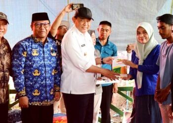 Gubernur Gorontalo Gusnar Ismail menyerahkan bantuan benih jagung kepada petani di Kelurahan Bulota, Kecamatan Limboto, Kabupaten Gorontalo, Jumat (17/4). (Foto : Haris/diskominfotik)