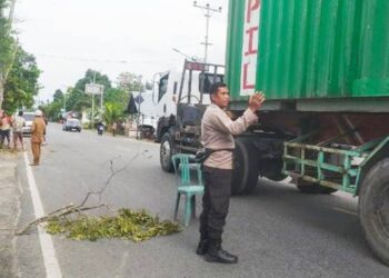 Personel Polsek Limboto Barat saat melakukan pengamanan di Jalan Trans Sulawesi, ketika dilakukan penebangan pohon.