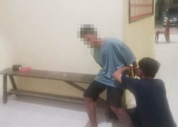 Tersangka dugaan penganiayaan ibu kadung diborgol polisi.