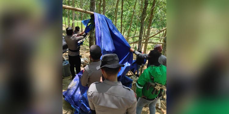 Petugas membongkar tenda terpal milik para penambang ilegal di atas bukit Desa Batu Kramat