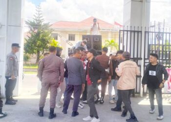 AMMPD menggelar unjuk rasa di depan Kantor Kejati Gorontalo, Rabu (6/5/2026), dengan membentangkan spanduk tuntutan penuntasan dugaan kasus TIK, tidak tebang pilih. (Foto: Istimewa).