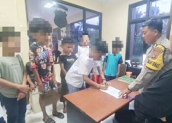 Petugas kepolisian saat mengamankan para siswa di Tilango Kabupaten Gorontalo yang kedapatan tengah pesta miras.