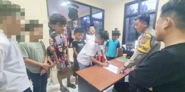 Petugas kepolisian saat mengamankan para siswa di Tilango Kabupaten Gorontalo yang kedapatan tengah pesta miras.