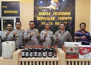 Kapolsek Marisa, AKP James Q. Derek,S.H. bersama anggota, memperlihatkan barang bukti minuman keras (Miras) yang berhasil disita dari sejumlah tempat hiburan malam.