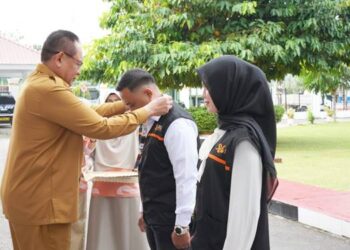SENSUS EKONOMI- Gubernur Gorontalo Gusnar Ismail menyematkan tanda pengenal petugas lapangan Sensus Ekonomi 2026 pada apel siaga di halaman rumah jabatan gubernur, Senin (15/6). ( Foto : Dok-Pemprov/Valen)