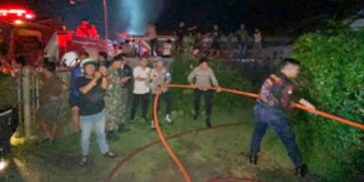 Petugas Damkar berusaha memadamkan kobaran api yang melahap rumah milik Kadus Bunggalo. (foto: Istimewa)
