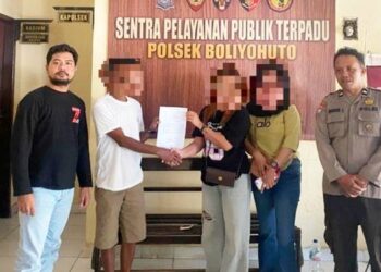 Seorang emak-emak inisial EP saat didamaikan dengan seorang pria insiial ET pelaku yang dilaporkan memepet sepeda motor EP saat berkendara di jalan raya.
