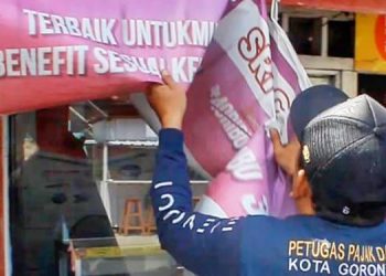 Petugas Bapenda Kota Gorontalo tengah menertibkan reklame liar. (Foto: Kominfo)