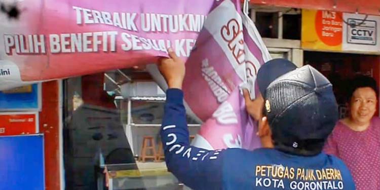 Petugas Bapenda Kota Gorontalo tengah menertibkan reklame liar. (Foto: Kominfo)